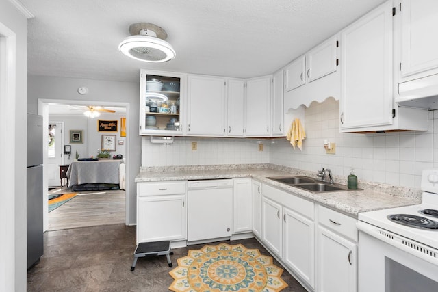 kitchen with white appliances, white cabinets, light countertops, under cabinet range hood, and a sink