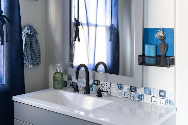 details featuring vanity and decorative backsplash