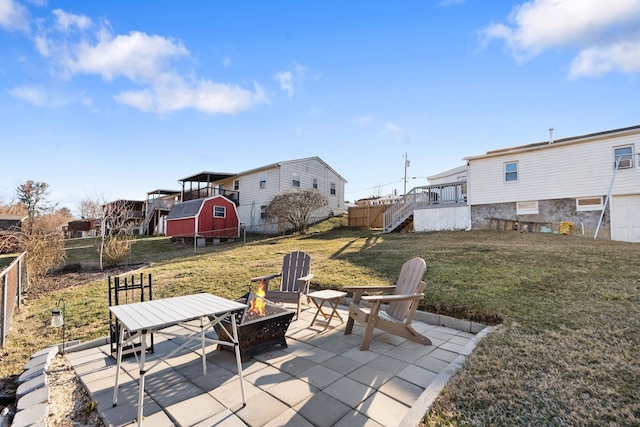 view of patio featuring an outdoor fire pit, stairway, and fence