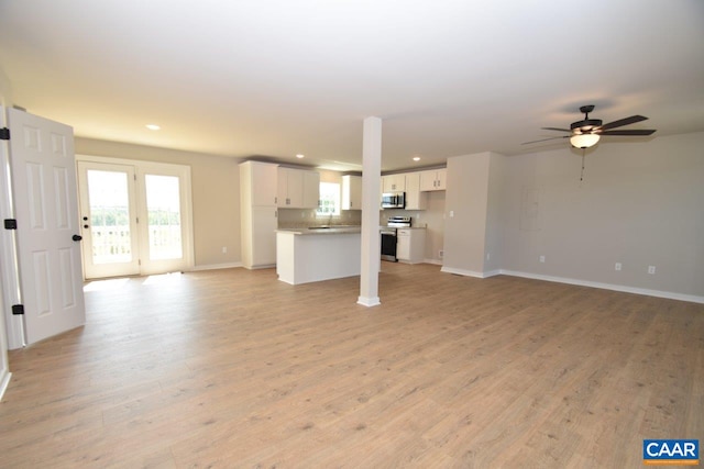 unfurnished living room featuring ceiling fan and light wood-type flooring