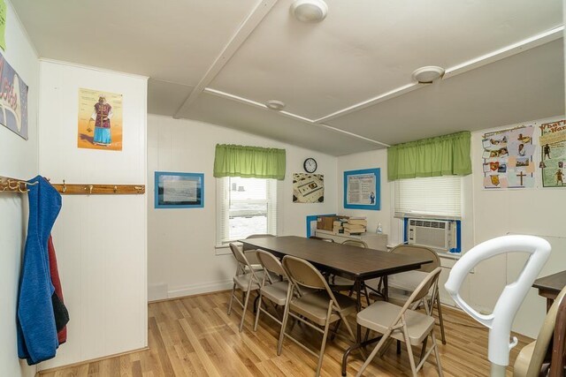 dining area featuring lofted ceiling, cooling unit, and light hardwood / wood-style floors