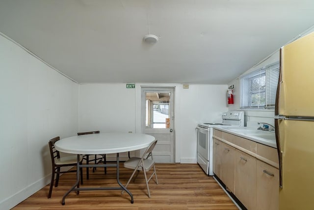 kitchen with hardwood / wood-style floors, electric range, fridge, and light brown cabinets