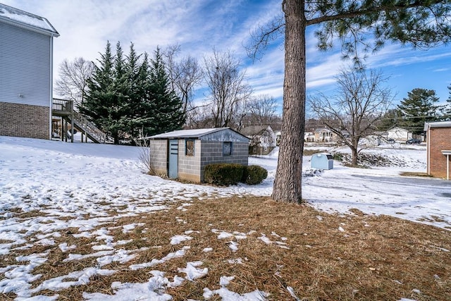 yard covered in snow featuring a storage unit