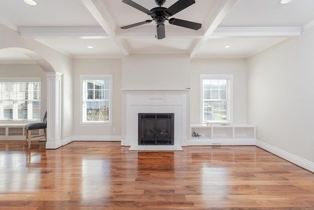 unfurnished living room featuring beam ceiling, coffered ceiling, and light hardwood / wood-style floors