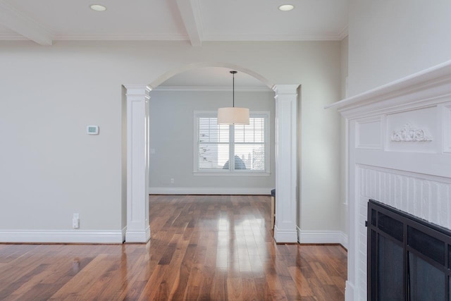 unfurnished living room featuring dark wood-type flooring, beamed ceiling, crown molding, and ornate columns