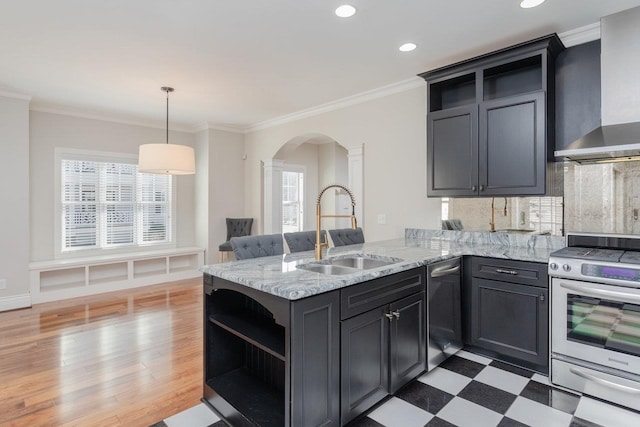 kitchen with pendant lighting, sink, kitchen peninsula, wall chimney range hood, and stainless steel gas range