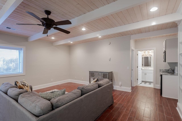 living room featuring dark hardwood / wood-style floors, ceiling fan with notable chandelier, beamed ceiling, sink, and wood ceiling