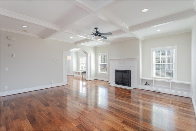 unfurnished living room with beamed ceiling, a fireplace, and hardwood / wood-style floors