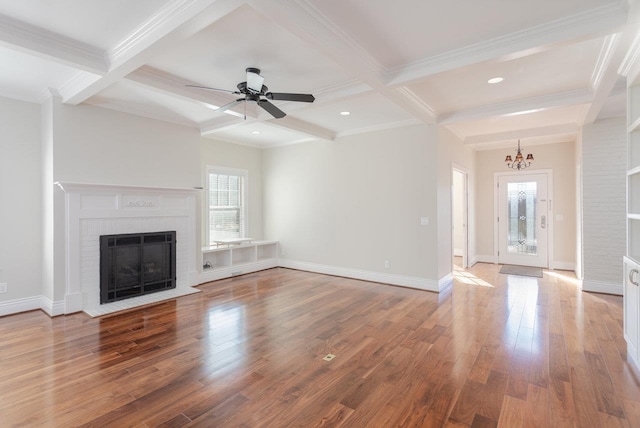 unfurnished living room featuring beamed ceiling, coffered ceiling, hardwood / wood-style floors, and a fireplace