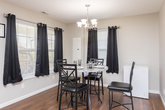 dining space featuring visible vents, baseboards, dark wood-style floors, and a chandelier