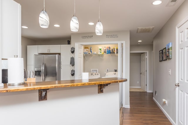 kitchen with visible vents, recessed lighting, dark wood-type flooring, stainless steel refrigerator with ice dispenser, and decorative light fixtures