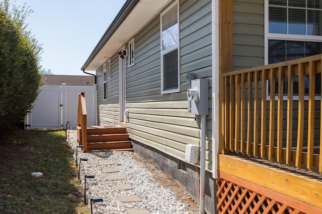 view of side of property featuring fence and a gate