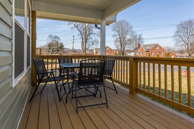 wooden deck featuring outdoor dining space and a residential view