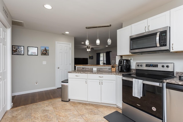 kitchen with white cabinetry, a peninsula, visible vents, and stainless steel appliances