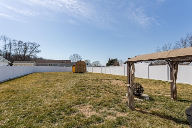 view of yard with a storage unit, an outdoor structure, and a fenced backyard