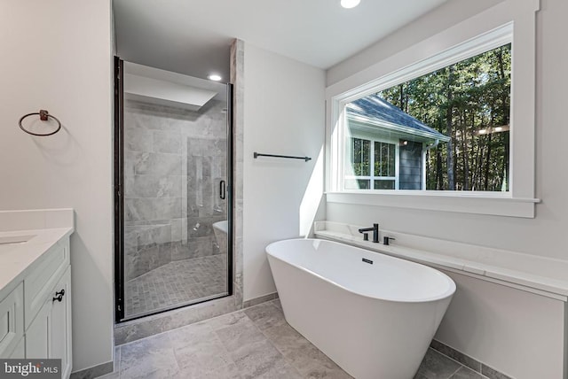 full bath featuring a stall shower, baseboards, a freestanding bath, vanity, and recessed lighting