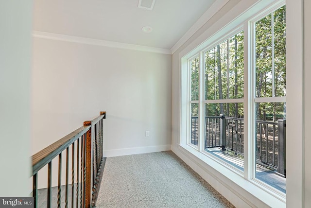 corridor with carpet, plenty of natural light, baseboards, and crown molding