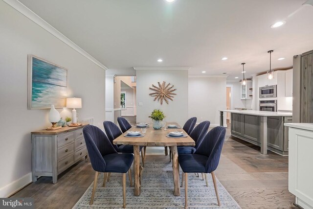 dining space featuring hardwood / wood-style flooring and crown molding