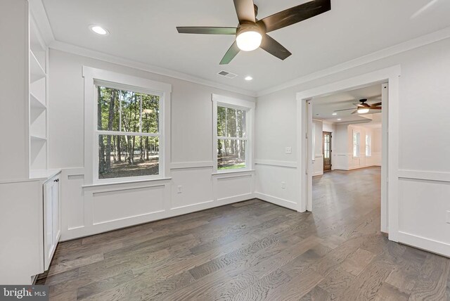 unfurnished room with crown molding, ceiling fan, and dark hardwood / wood-style flooring