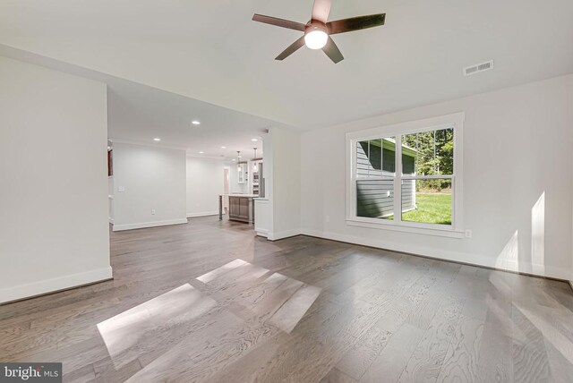 unfurnished living room with recessed lighting, wood finished floors, a ceiling fan, visible vents, and baseboards