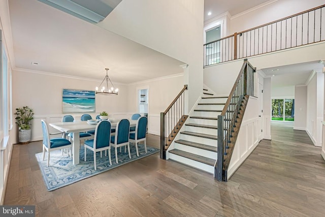 dining space with a notable chandelier, stairs, ornamental molding, and wood finished floors