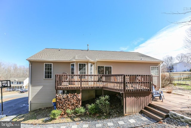 rear view of house with a wooden deck and a shingled roof