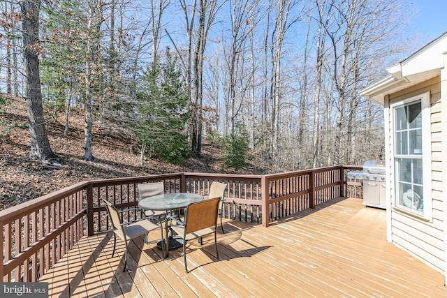 wooden deck featuring grilling area and outdoor dining space