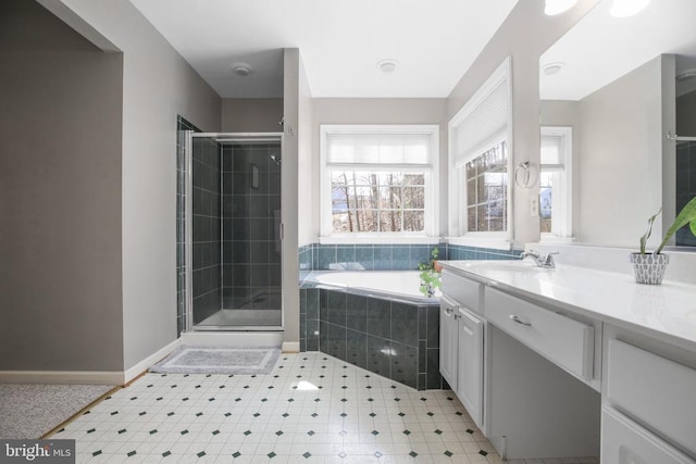 bathroom with vanity, a garden tub, baseboards, and a stall shower