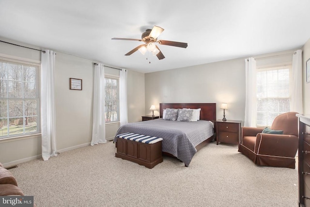 carpeted bedroom featuring visible vents, baseboards, and ceiling fan