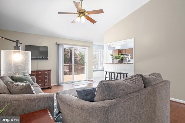 living room with high vaulted ceiling, baseboards, ceiling fan, and wood finished floors