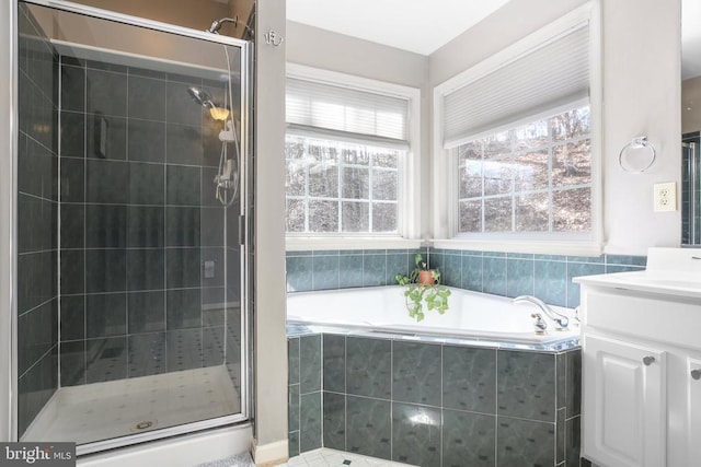 bathroom featuring a bath, a shower stall, and vanity