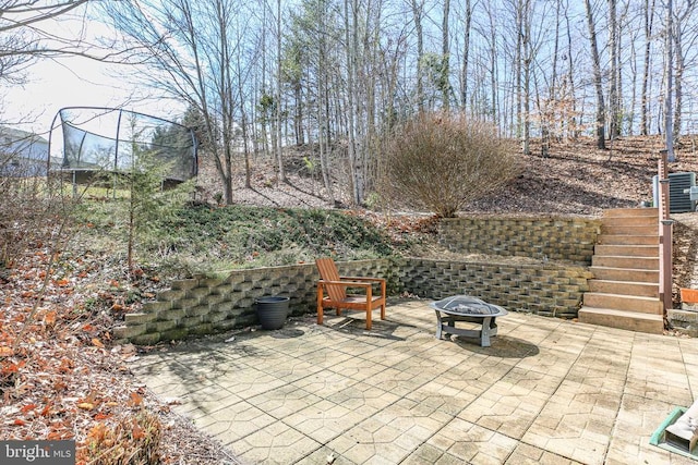 view of patio / terrace with a fire pit, stairs, and central AC