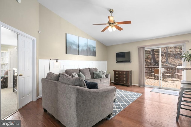 living area with a ceiling fan, vaulted ceiling, wood finished floors, and baseboards