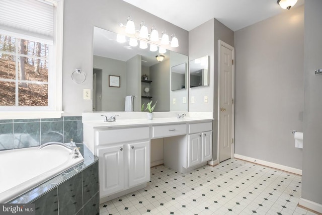 bathroom featuring a bath, double vanity, baseboards, and a sink