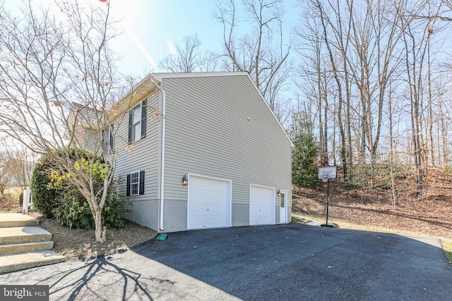 view of side of property with driveway and a garage