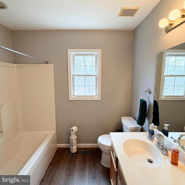 bathroom featuring visible vents, toilet, a healthy amount of sunlight, and wood finished floors