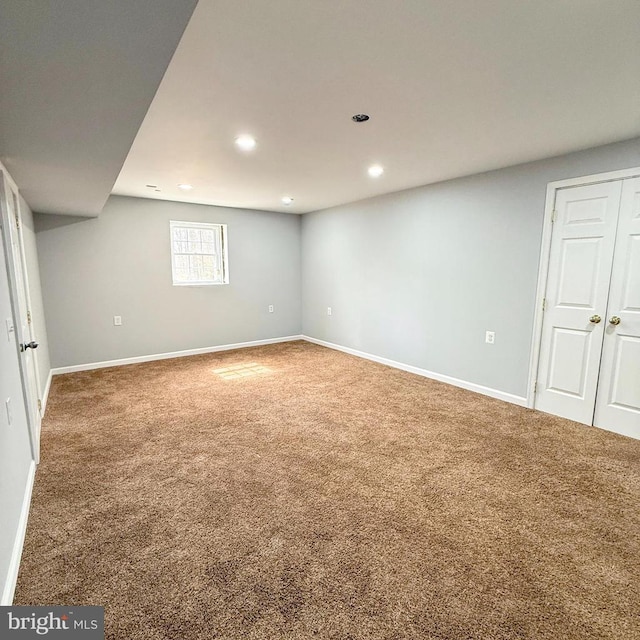 below grade area featuring recessed lighting, baseboards, and carpet