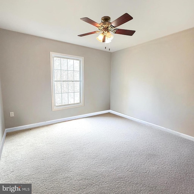 carpeted empty room with a ceiling fan and baseboards