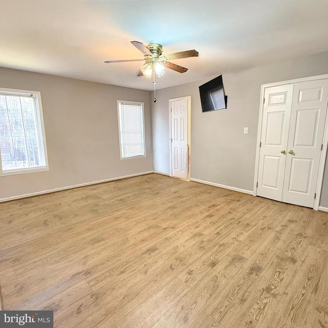 empty room featuring ceiling fan, baseboards, and wood finished floors