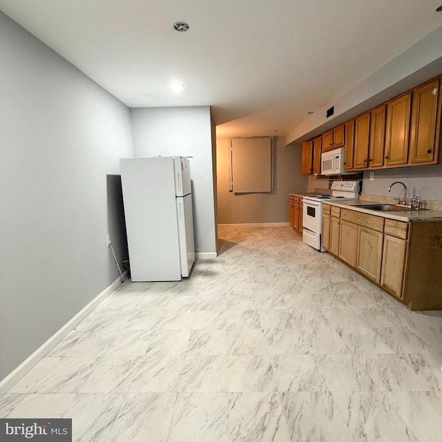 kitchen featuring white appliances, brown cabinets, baseboards, and a sink