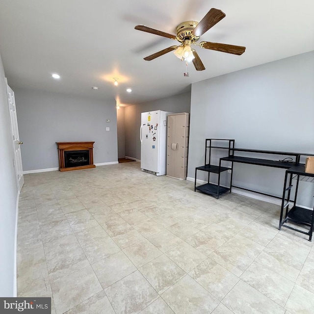 interior space featuring ceiling fan, baseboards, recessed lighting, a fireplace, and freestanding refrigerator