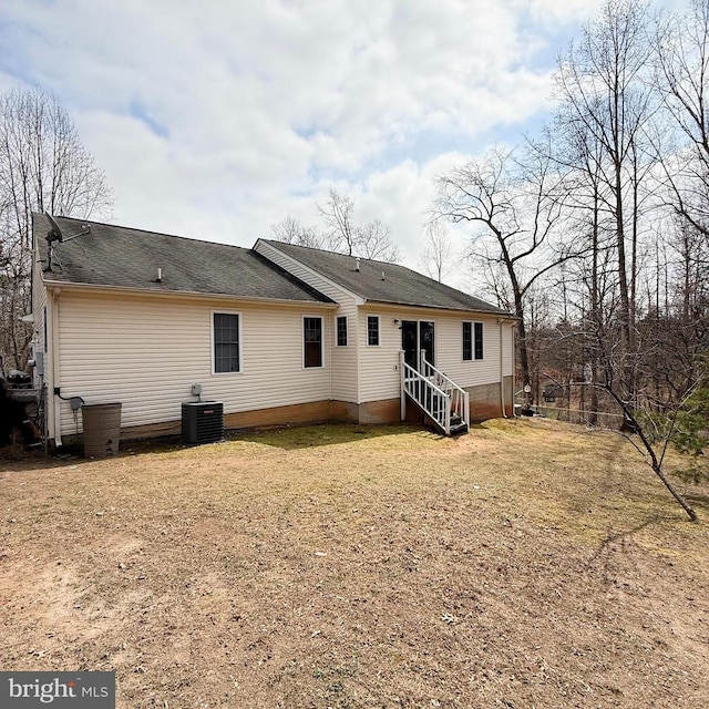 back of house featuring cooling unit, a yard, and entry steps