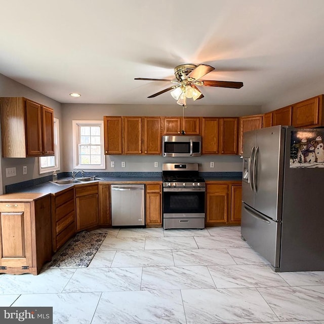 kitchen with a sink, stainless steel appliances, marble finish floor, and brown cabinetry