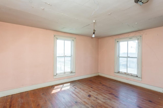 empty room with hardwood / wood-style flooring and a healthy amount of sunlight