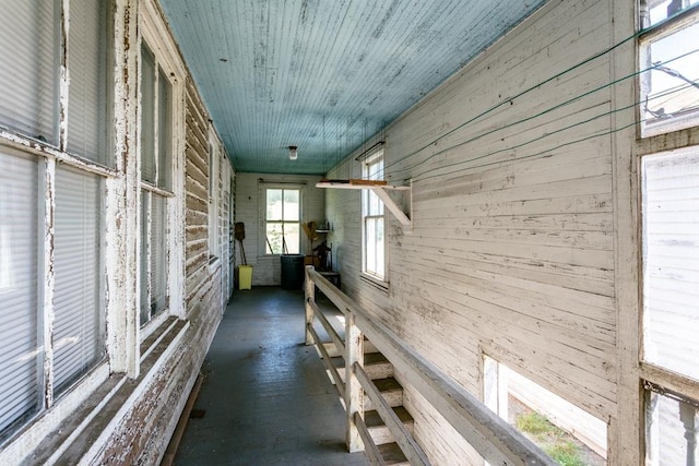 hall with wood ceiling and wooden walls