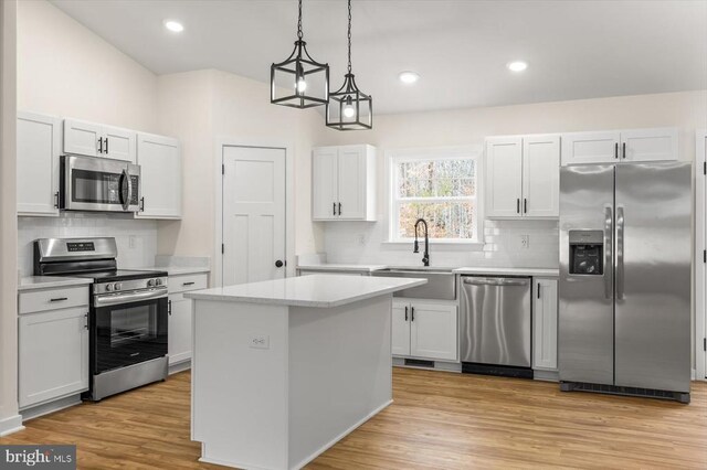 kitchen featuring white cabinetry, appliances with stainless steel finishes, a center island, and sink