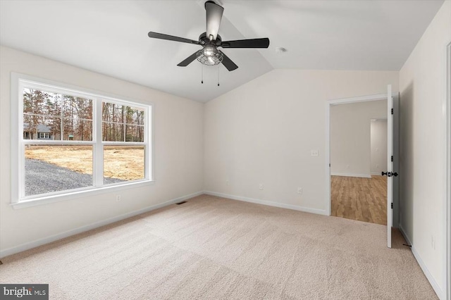 carpeted empty room with ceiling fan and lofted ceiling