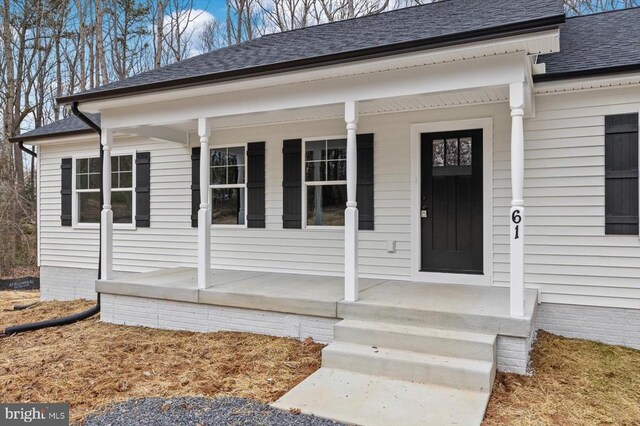 view of exterior entry featuring covered porch