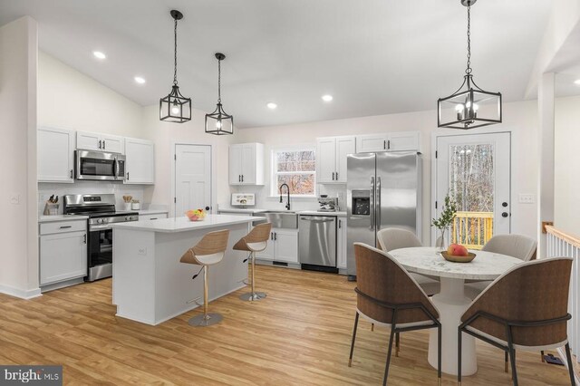 kitchen with stainless steel appliances, a kitchen island, and white cabinets