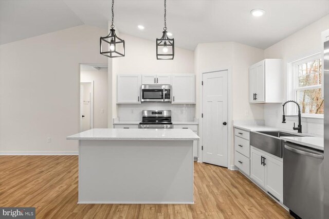 kitchen featuring white cabinetry, stainless steel appliances, and a kitchen island